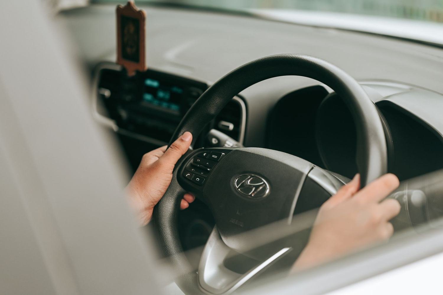 Duas mãos segurando o volante de um carro